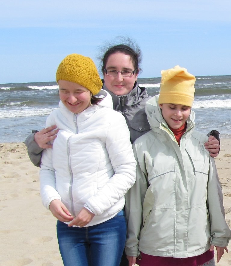 Wychowawczyni przytula uczennice na plaży nad morzem Bałtyckim.