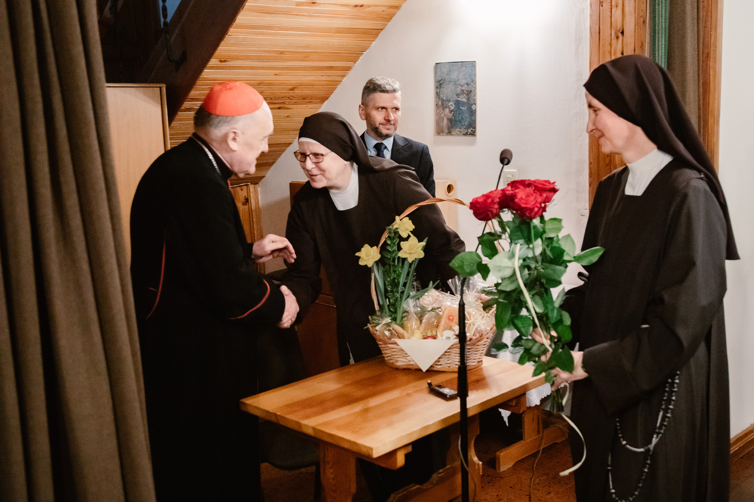Matka Judyta i s. Anastazja wręczają kosz z wypiekami i kwiaty księdzu kardynałowi Kazimierzowy Nyczowi.