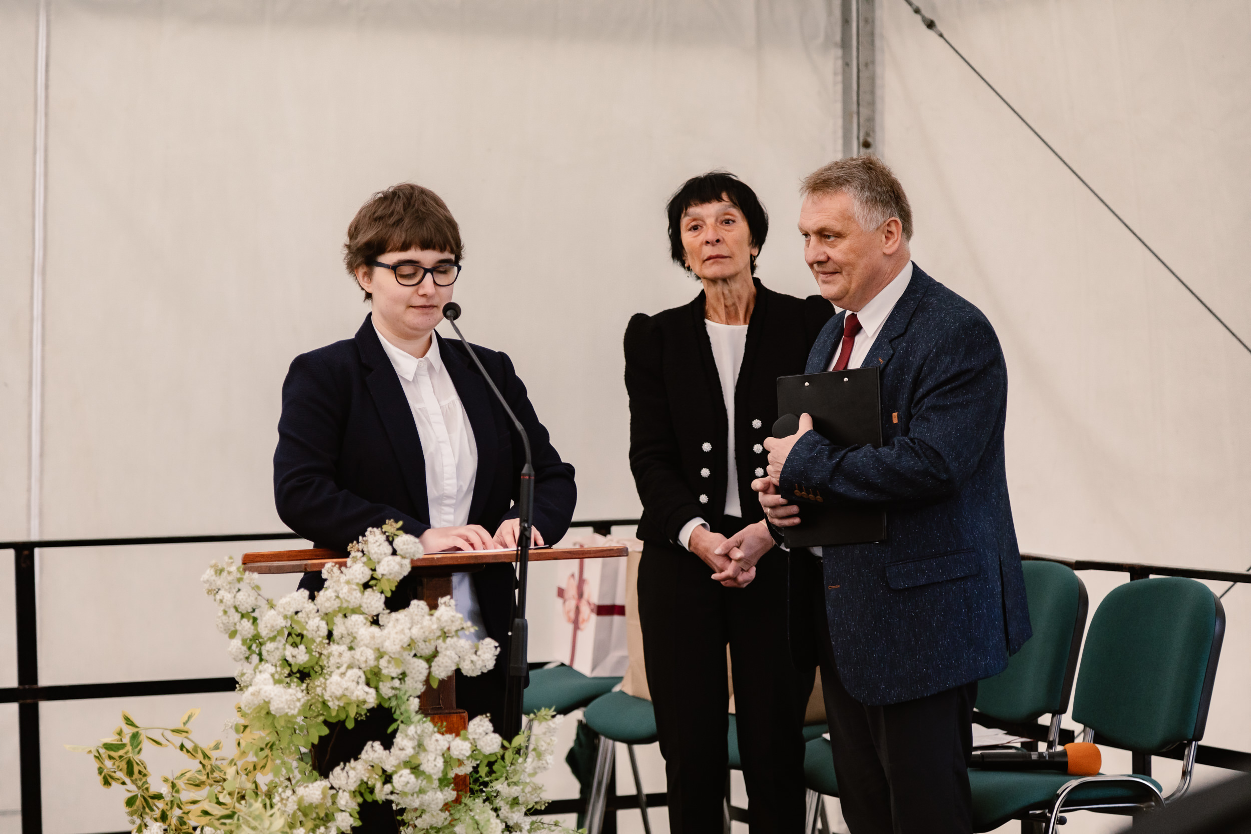 Jedna z uczennic odczytuje rotę ślubowania w imieniu pozostałych absolwentów. Za nią stoją dyrektor Elżbieta Szczepkowska i Piotr Dziuba.