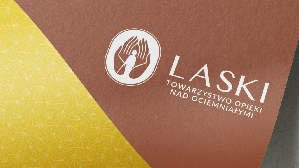 Logotyp Towarzystwa Opieki nad Ociemniałymi na brązowej kartce z żółtym wzorem.