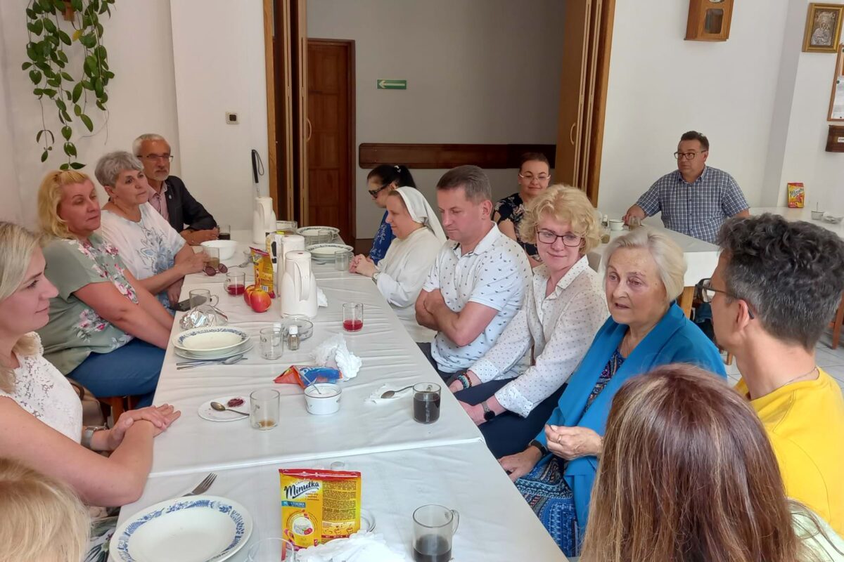 Absolwenci przy stole w domu rekolekcyjnym.