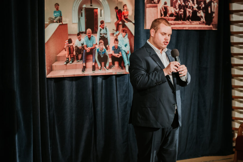 Piotr śpiewa piosenkę na scenie.