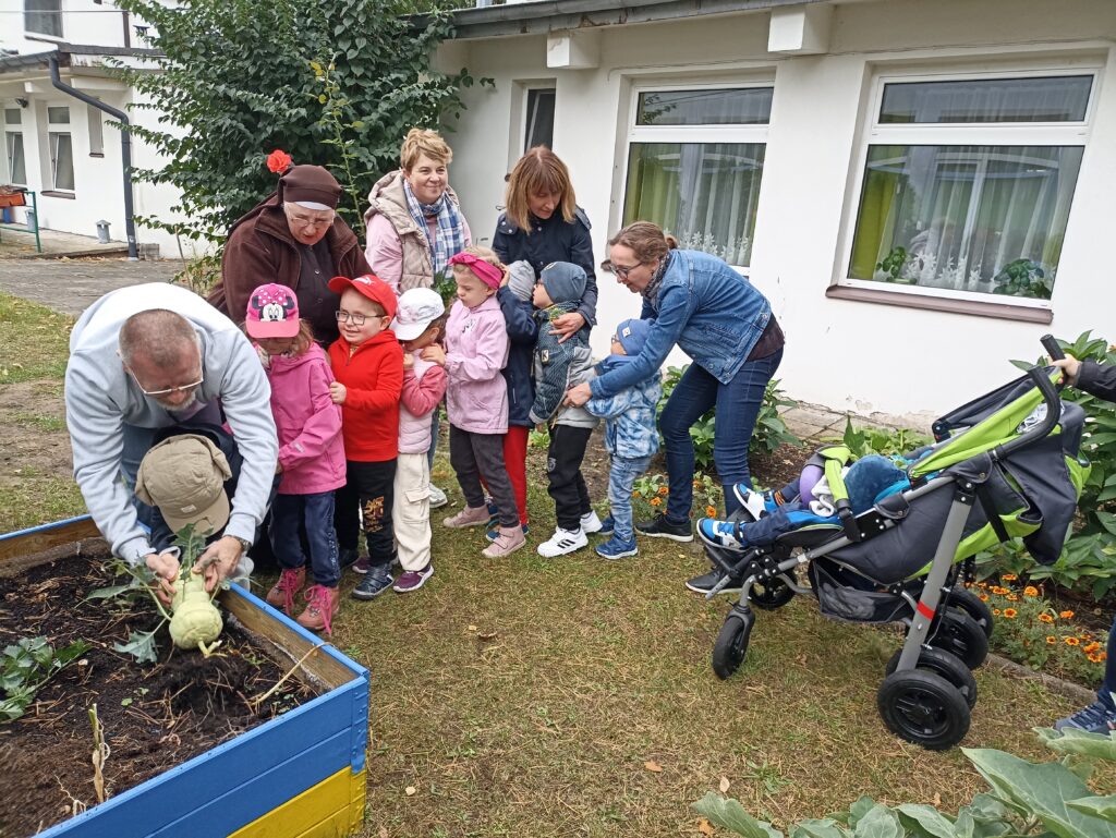 Dzieci stoją jedno za drugim - zabawa w ciągnięcie rzepki.