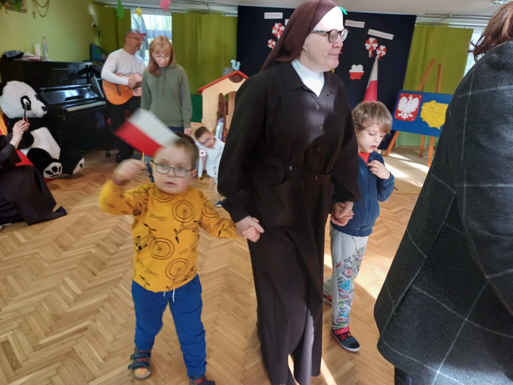 Siostra z dwoma chłopcami trzymającymi flagę.
