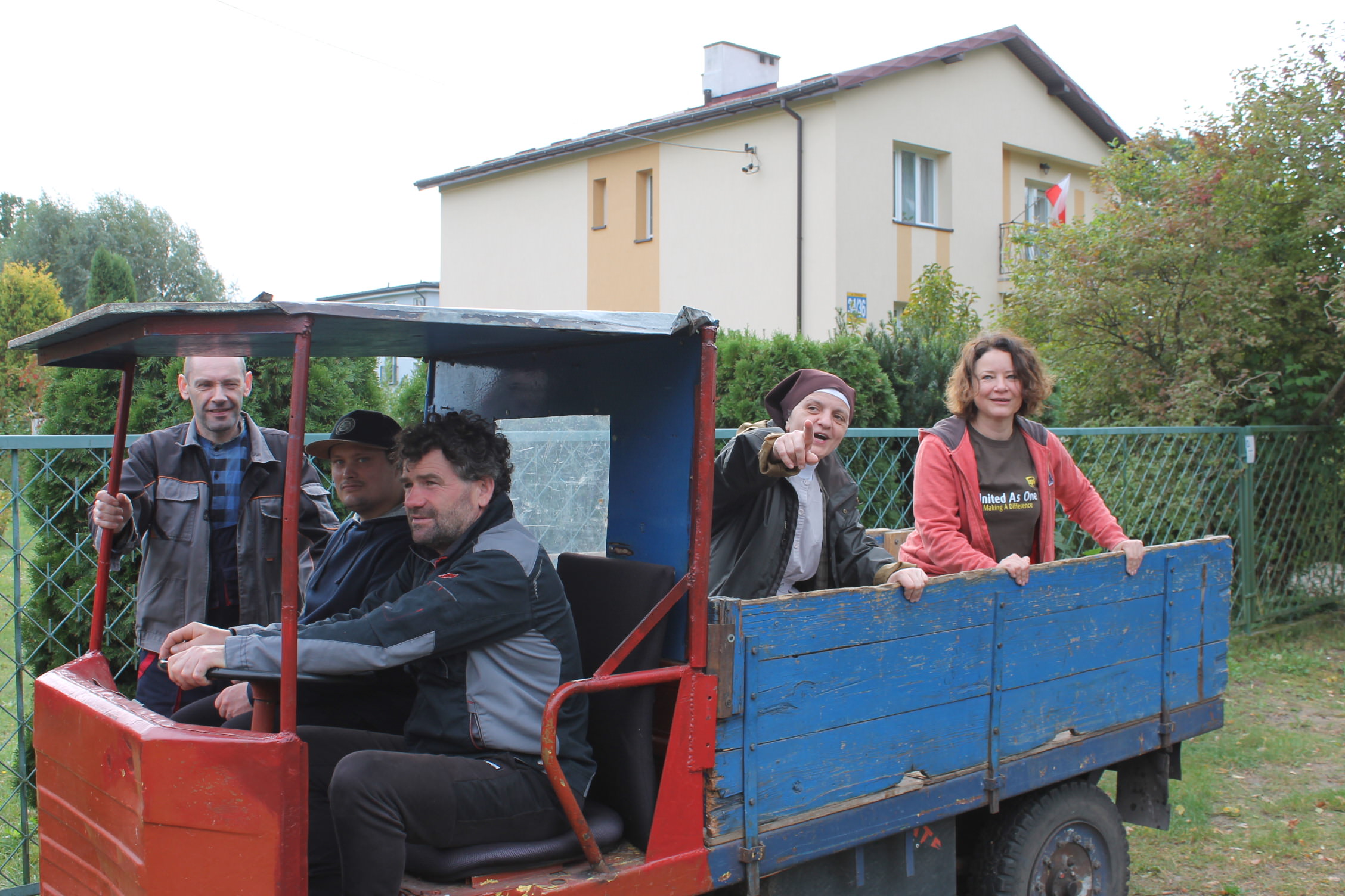 Wolontariusze jadą na elektrycznym samochodzie.