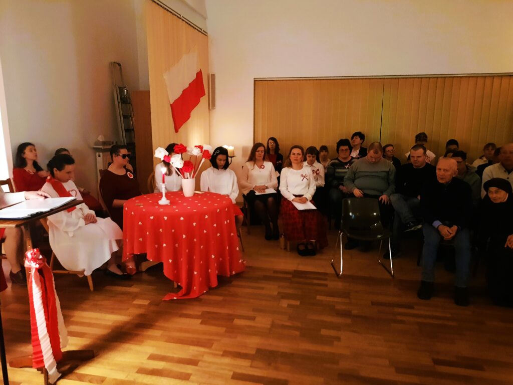 Wychowanki grup III, V, VII oraz przybyli goście siedzą na krzesłach na świetlicy