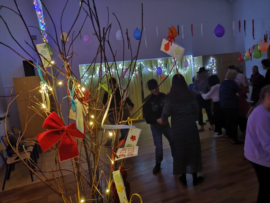 Na pierwszym planie Drzewko Andrzeja z myślami dotyczącymi przyszłości a dalej roztańczone pary