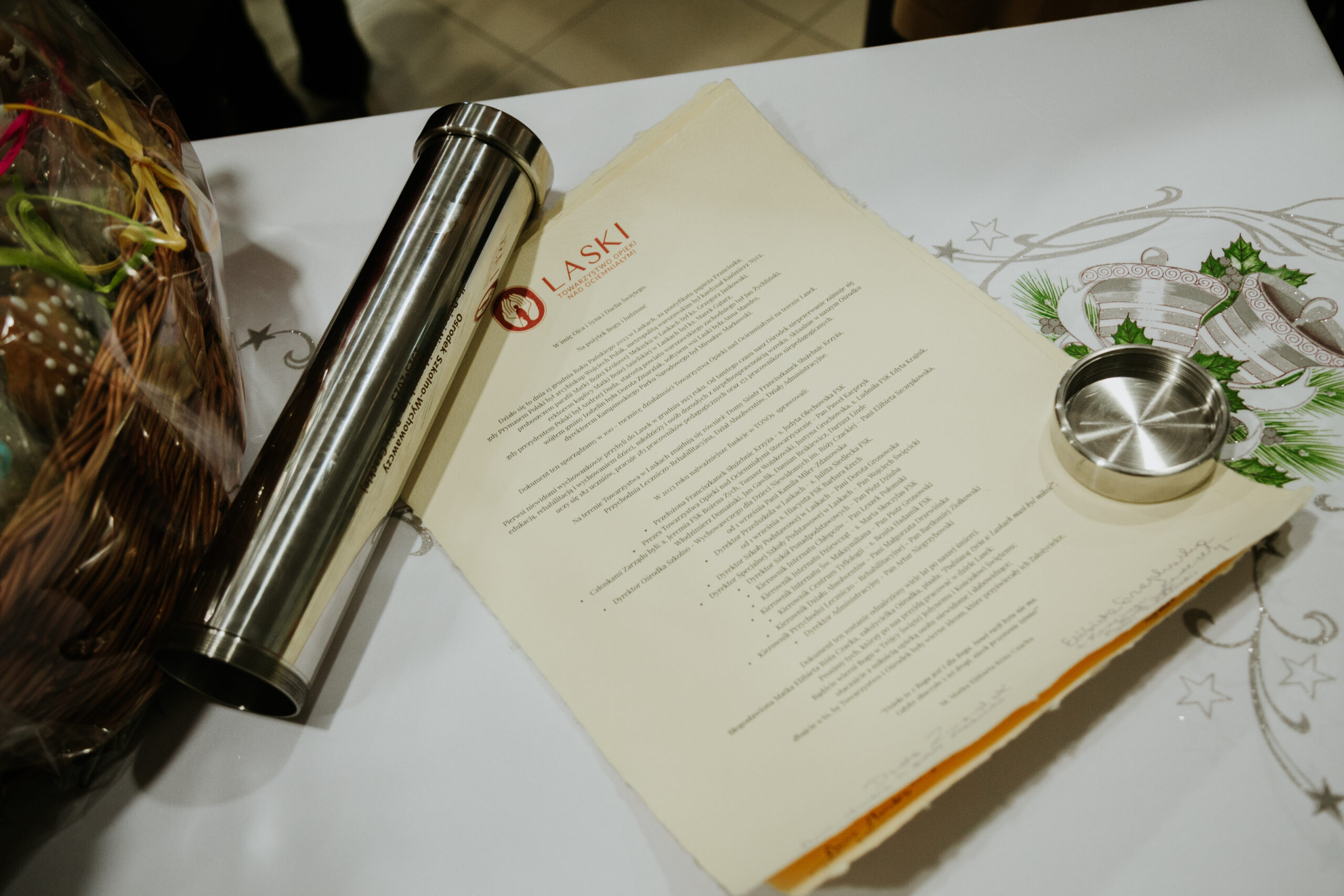 Metalowa tuba - kapsuła czasu. Obok niej leży akt na papierze czerpanym z podpisami.