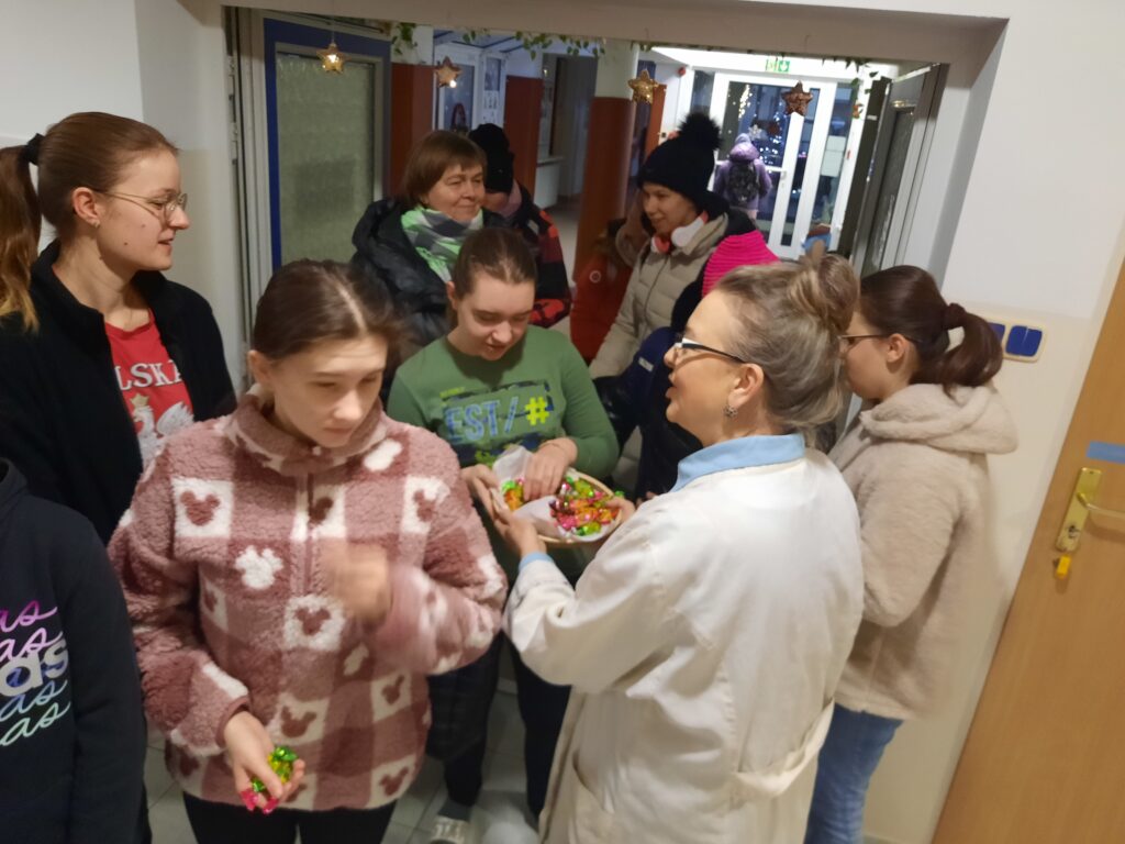 Pani Małgosia częstuje  dziewczęta cukierkami 