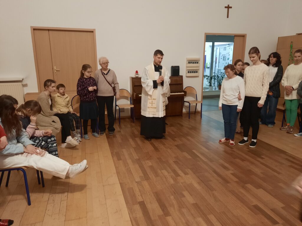 Ksiądz Sebastian zwraca się do uczestników spotkania