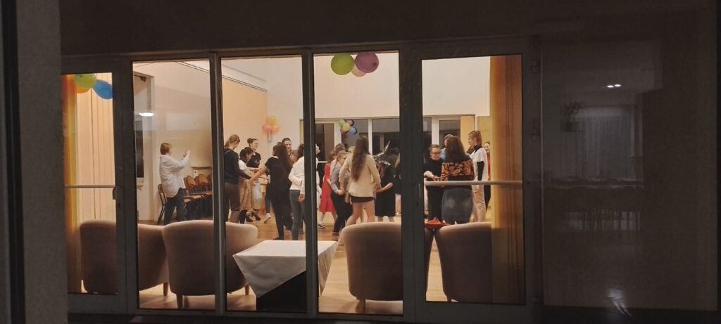 Przez okno z holu widok na bawiące się dziewczęta