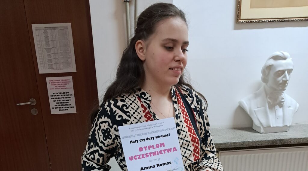 Amina prezentuje dyplom.