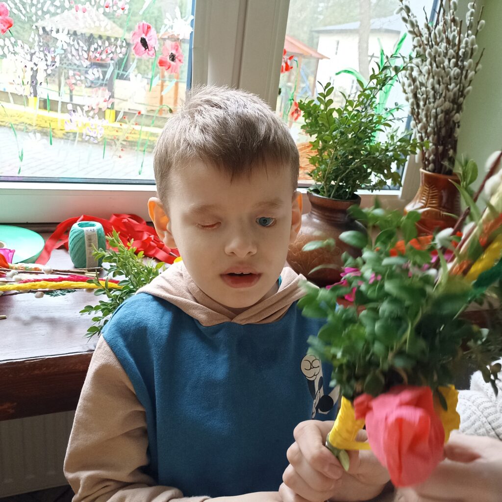 Chłopiec trzyma palmę.