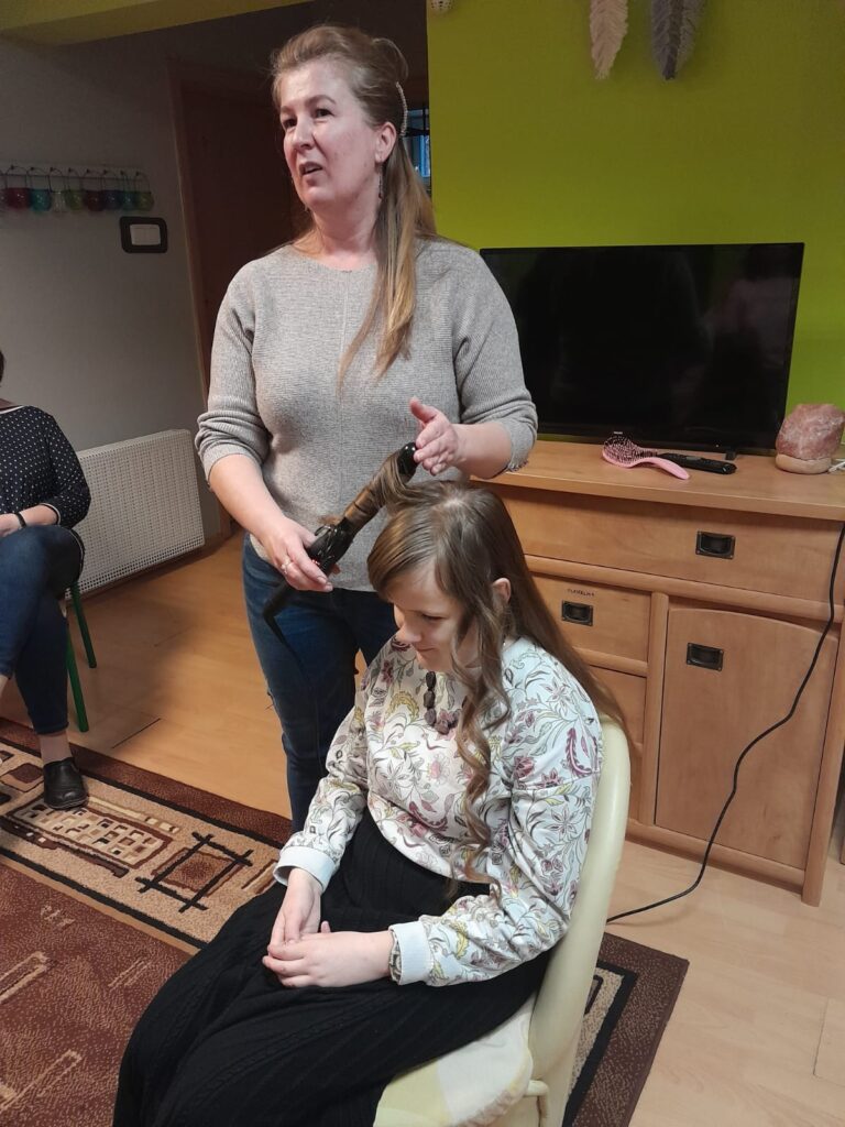 Pani Aneta na lokówce kręci  włosy Anastazji