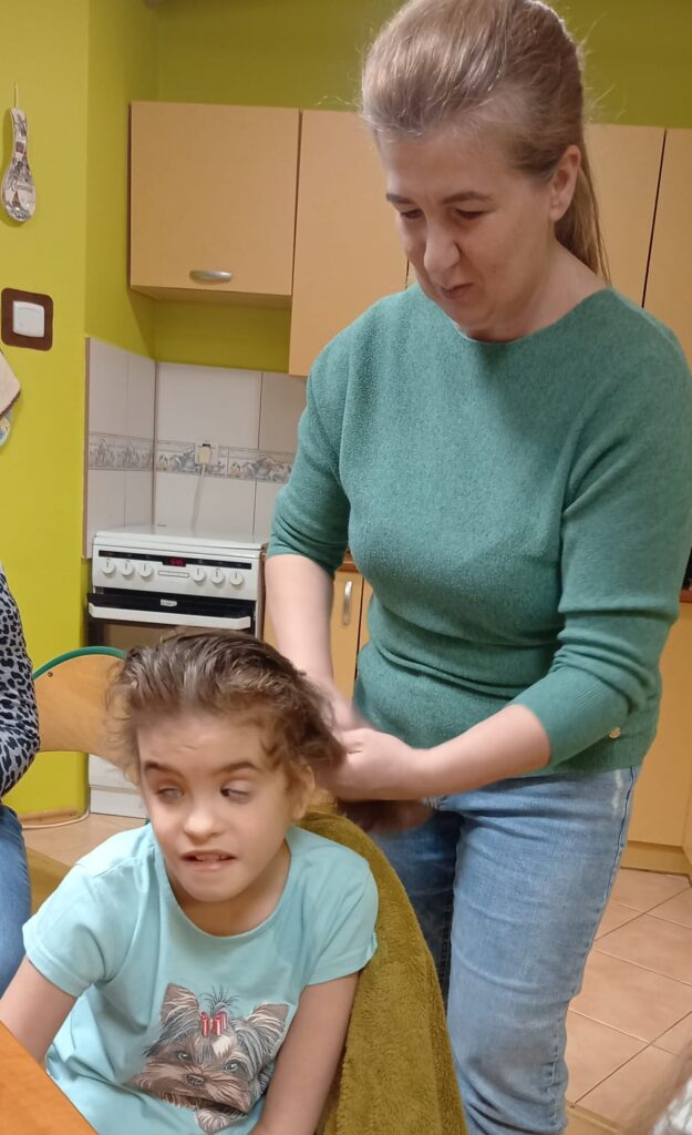 Pani Aneta  czesze włosy Mai