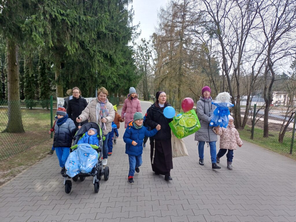 Grupa przedszkolaków z Paniami idzie jedną z alejek Ośrodka.