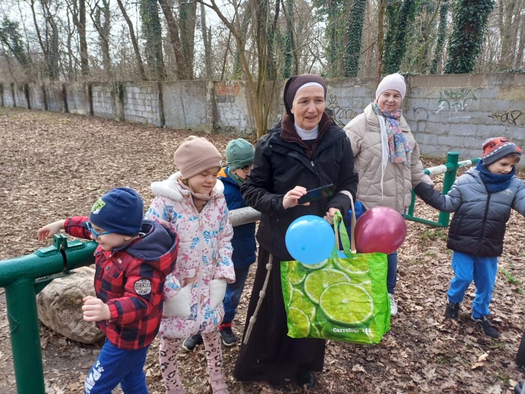 Przedszkolaki z Paniami stoją przy szlabanie.