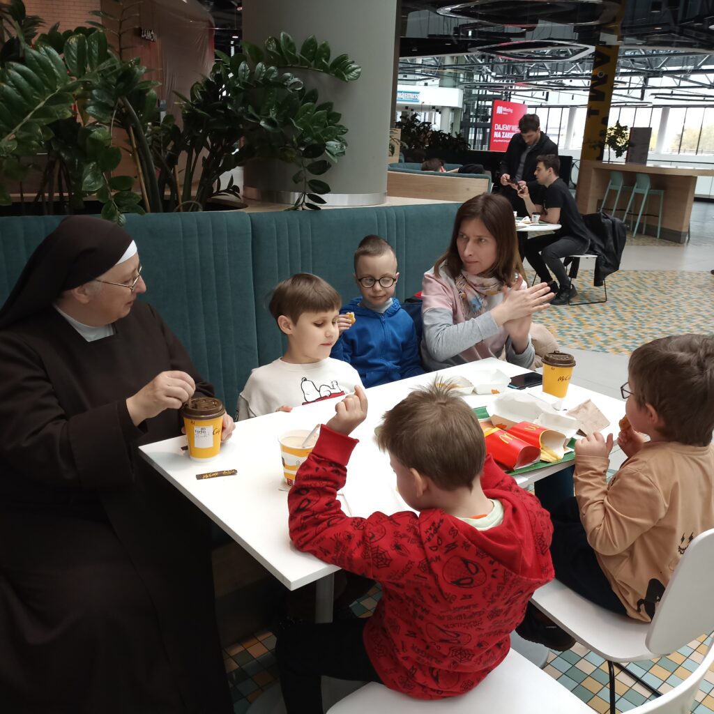 Przedszkolaki siedzą przy stole, na którym jest jedzenie z Mc. Donalds'a