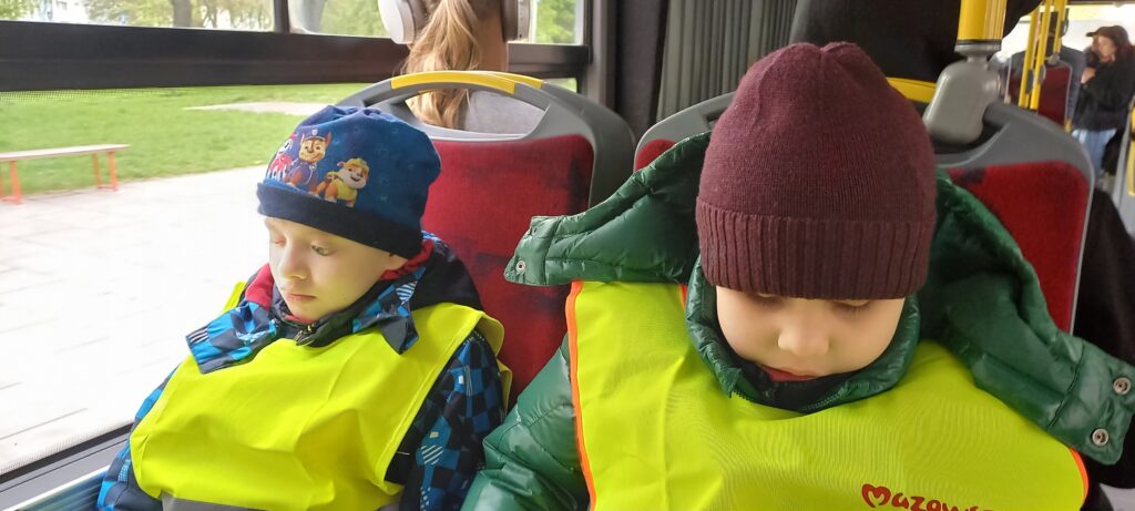 Dwóch chłopców siedzi na fotelach w autobusie