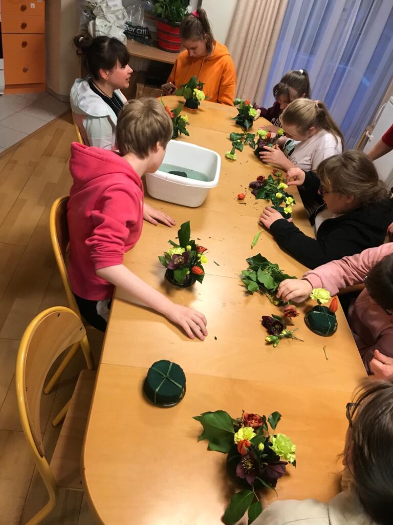 Dziewczęta układają kompozycje kwiatowe