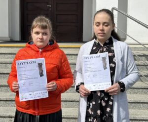 Anastasja i Amina prezentują dyplomy za udział w konkursie.