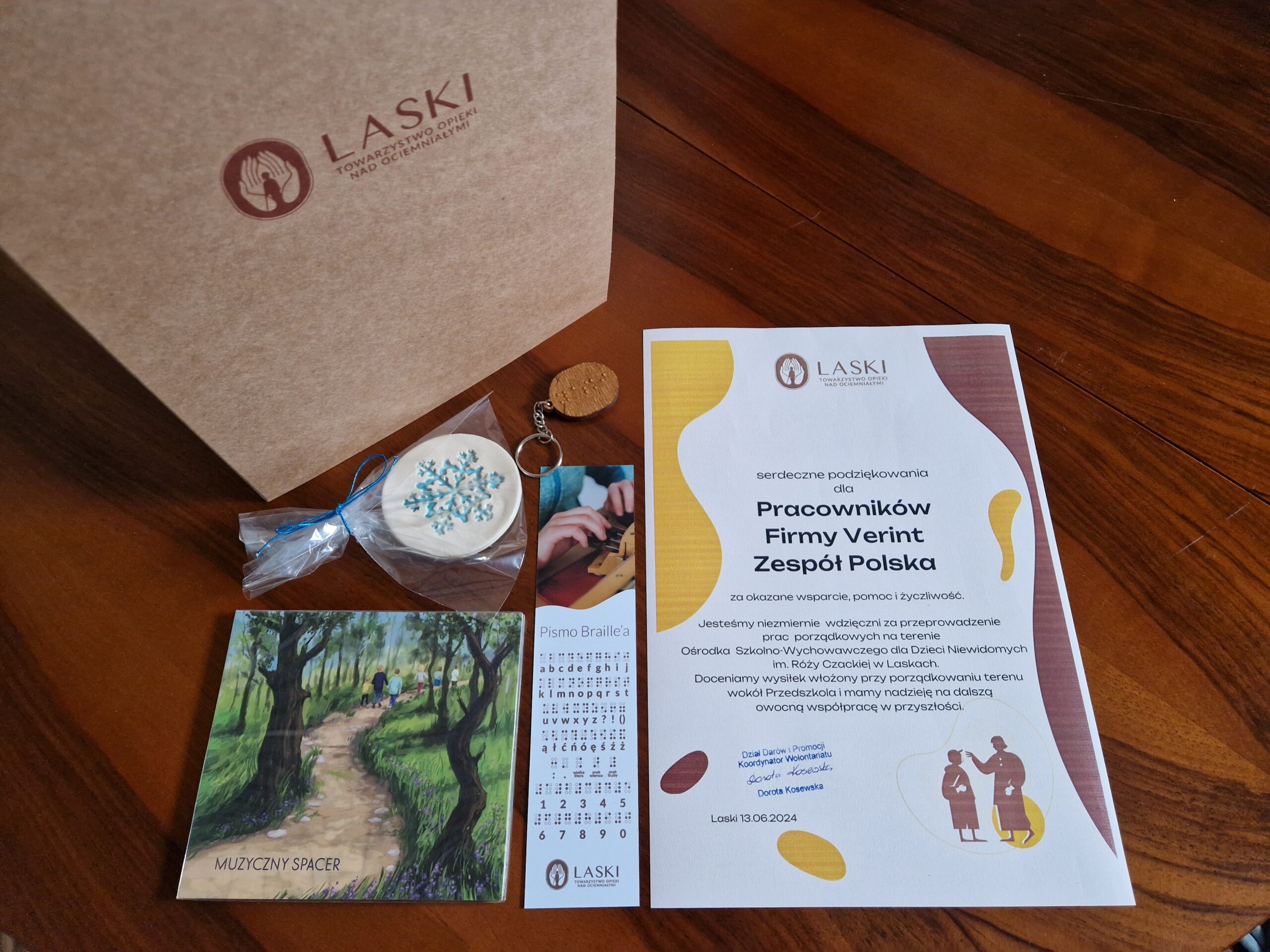 Na zdjęciu dyplom dla firmy Verint, płyta ze szkoły muzycznej w Laskach i drobne gadżety.
