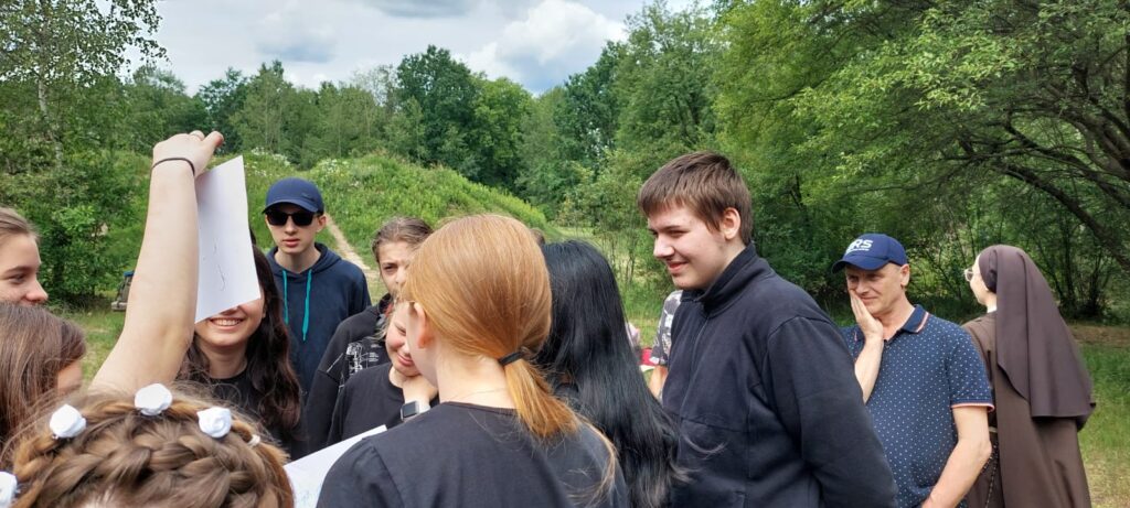 Grupka chłopaków czytająca kartkę na której jest hasło zabawy