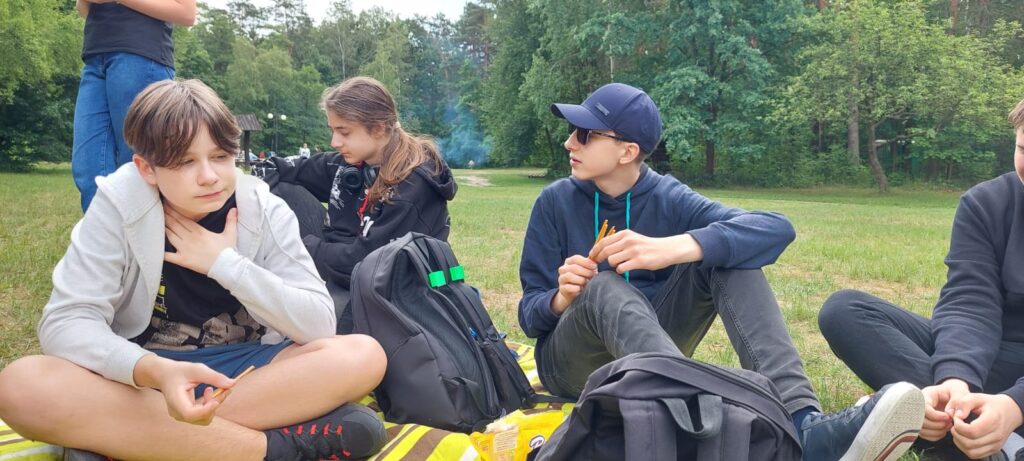 Na kocu siedzą chłopacy, rozmawiają