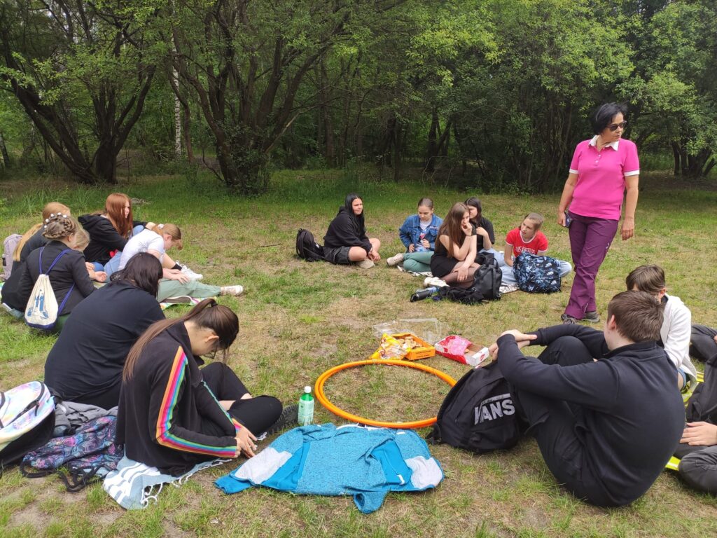 Wspólne zdjęcie jak dzieci siedzą w kółku i rozmawiają