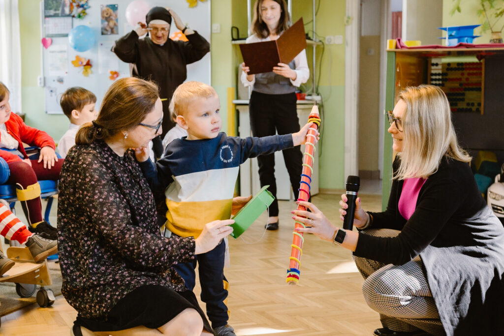Chłopiec ogląda duży ołówek - przyrząd do pasowania.