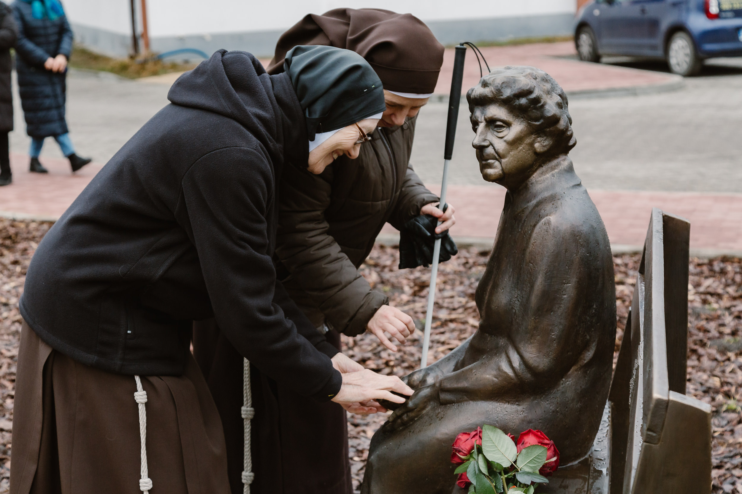 Niewidoma siostra Franciszkanka brajluje pomnik.