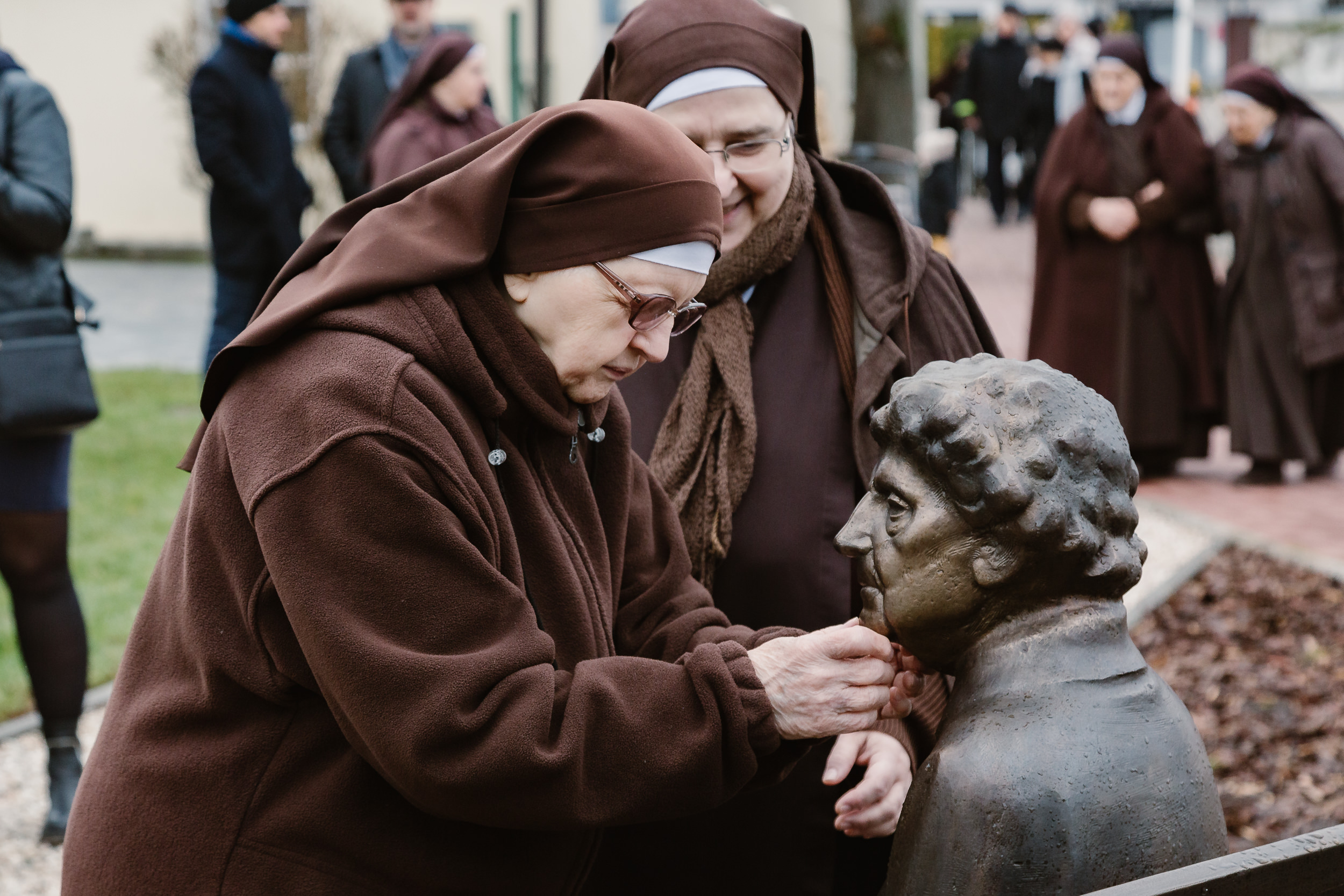 Niewidoma siostra Franciszkanka brajluje pomnik.