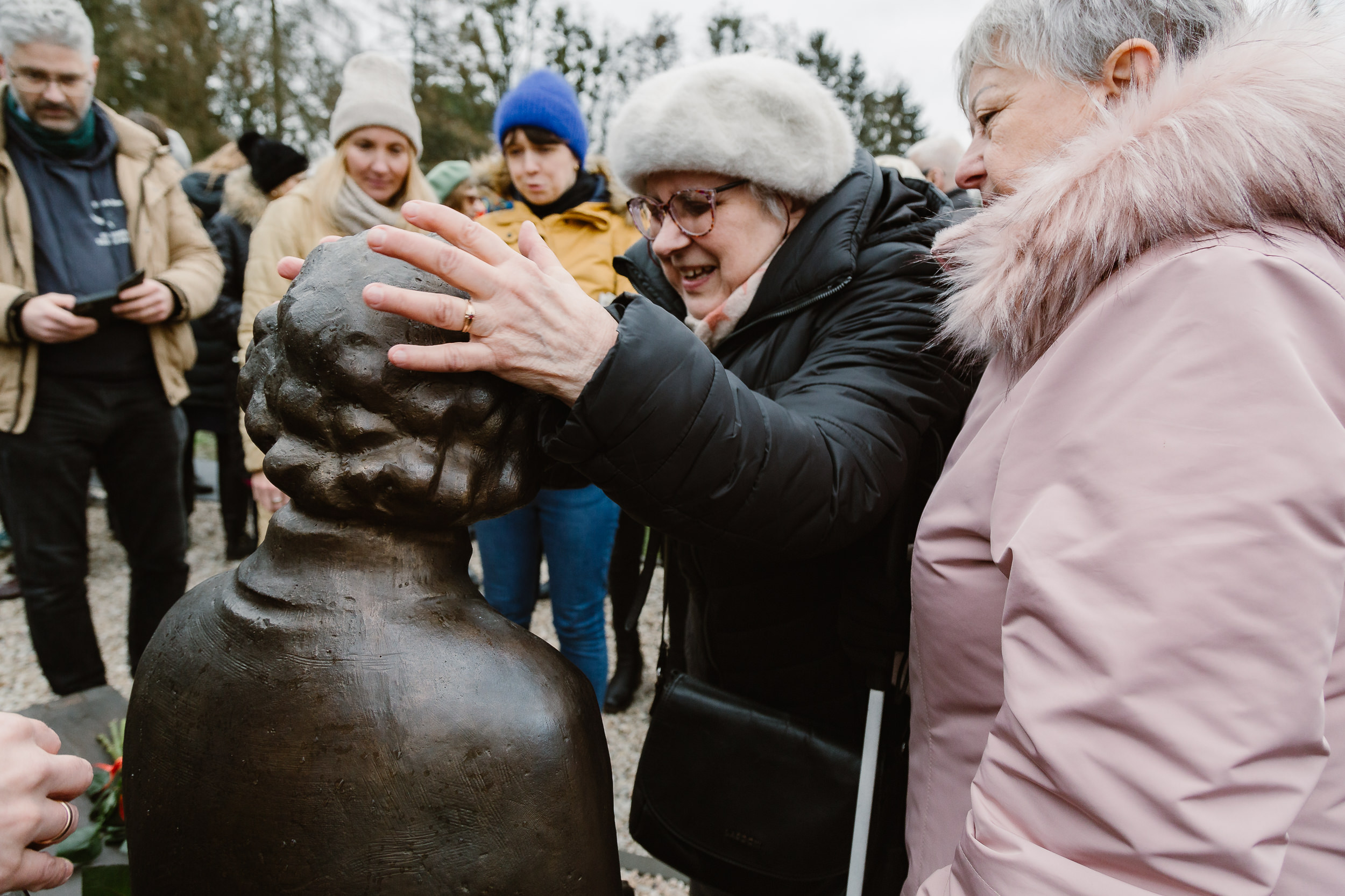 Niewidoma kobieta brajluje głowę pomnika.