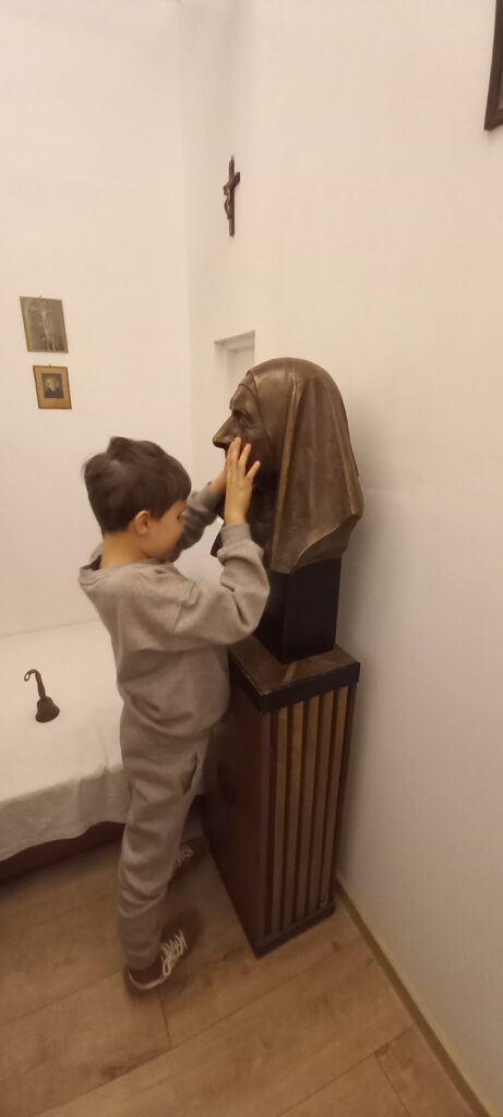 Chłopiec ogląda dłońmi popiersie Matki Elżbiety Róży Czackiej