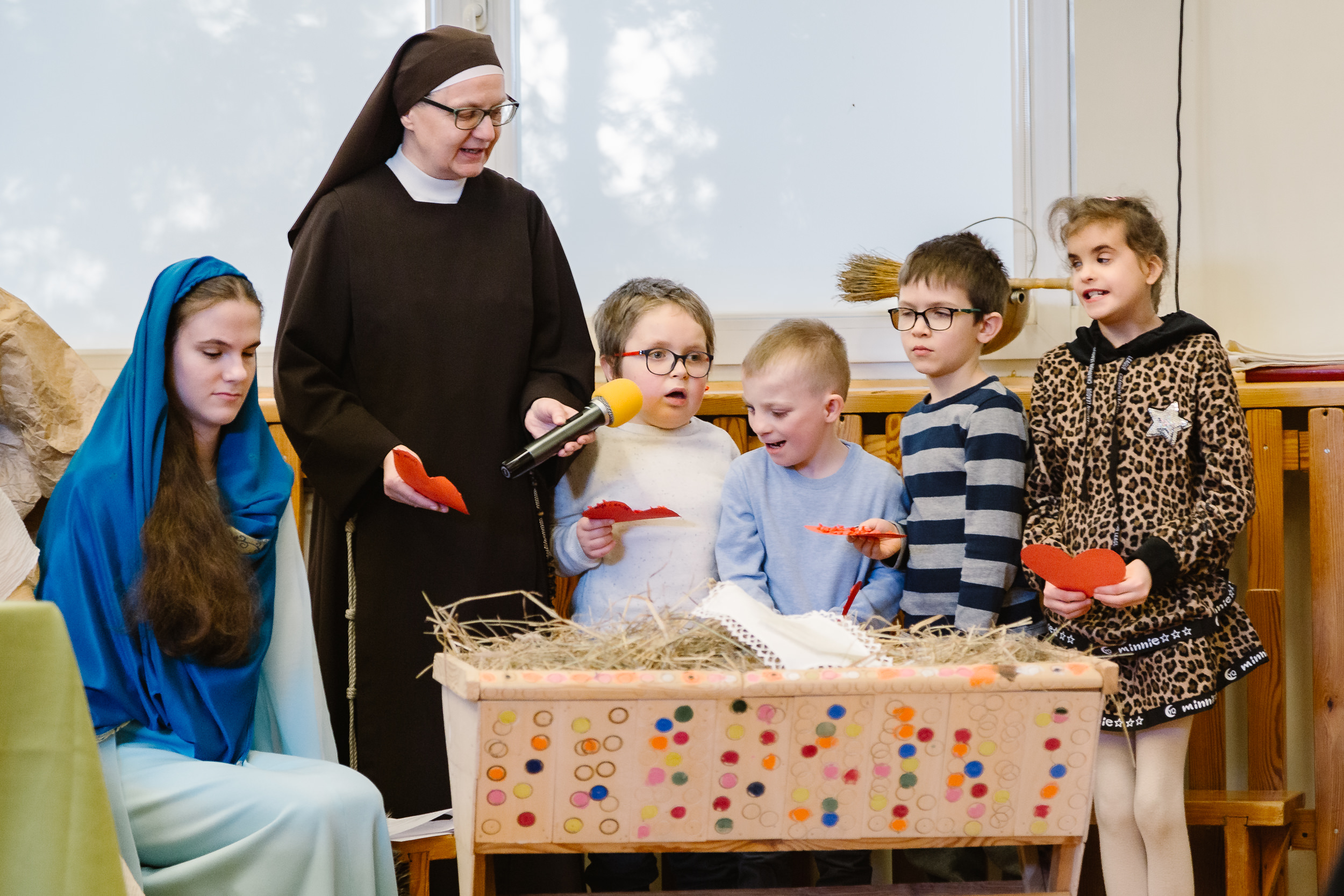 Przedszkolaki z Siostrą zakonną stoją przy żłóbku.