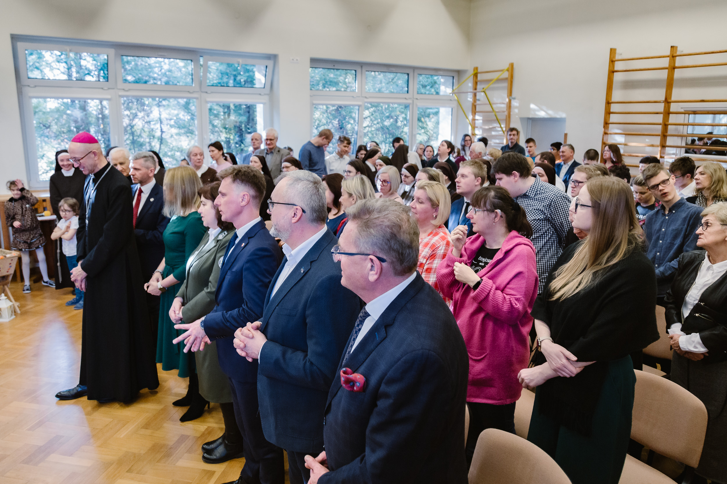 Widok na salę gimnastyczną wypełnioną po brzegi gośćmi.