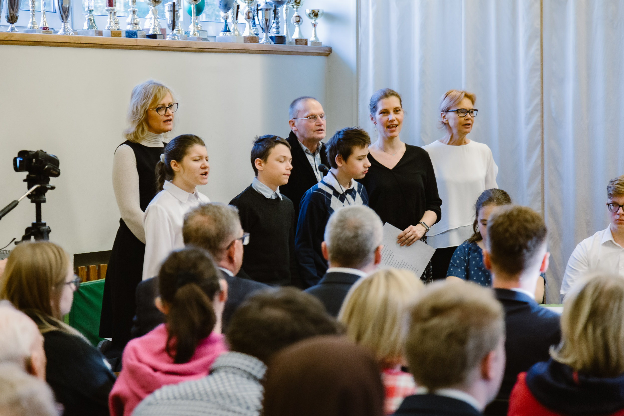Schola złożona z uczniów i nauczycieli śpiewa pieśń.