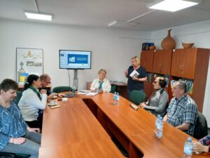 Pracownicy ZUS i uczestnicy spotkania siedzący wspólnie przy owalnym stole.