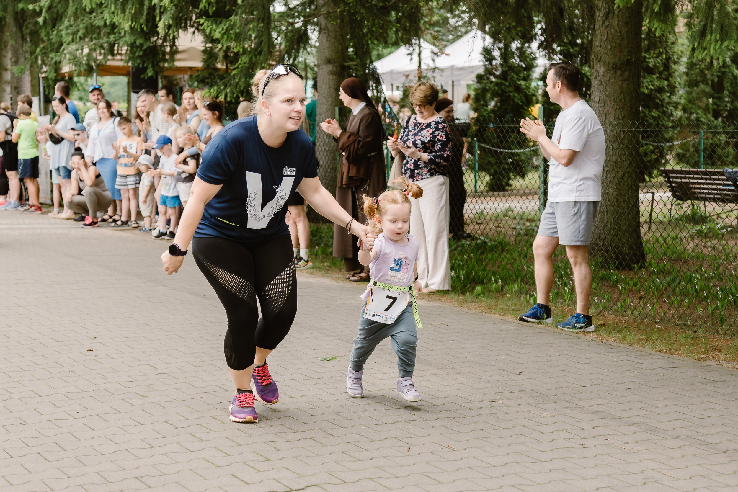 Mama biegnie z kilkuletnią córeczką.