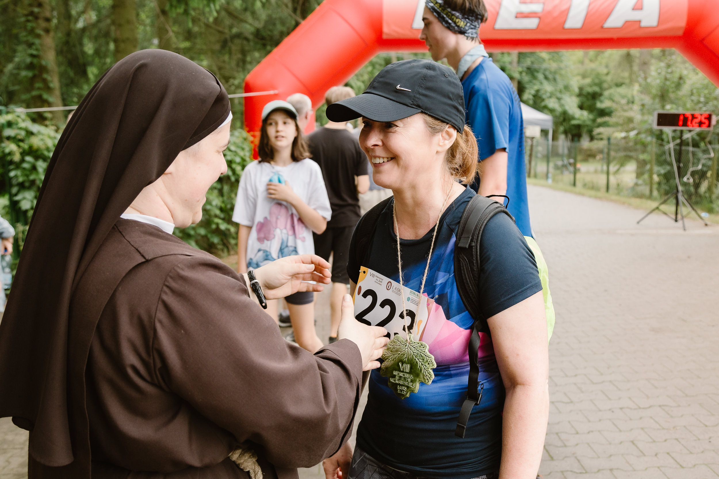 Franciszkanka gratuluje biegaczce kończącej zawody.