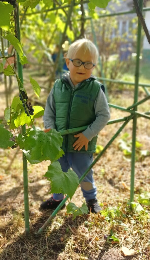 Chłopiec wśród liści winogron.