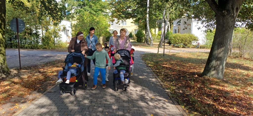 Grupa przedszkolaków i  nauczycielek wraca do przedszkola.