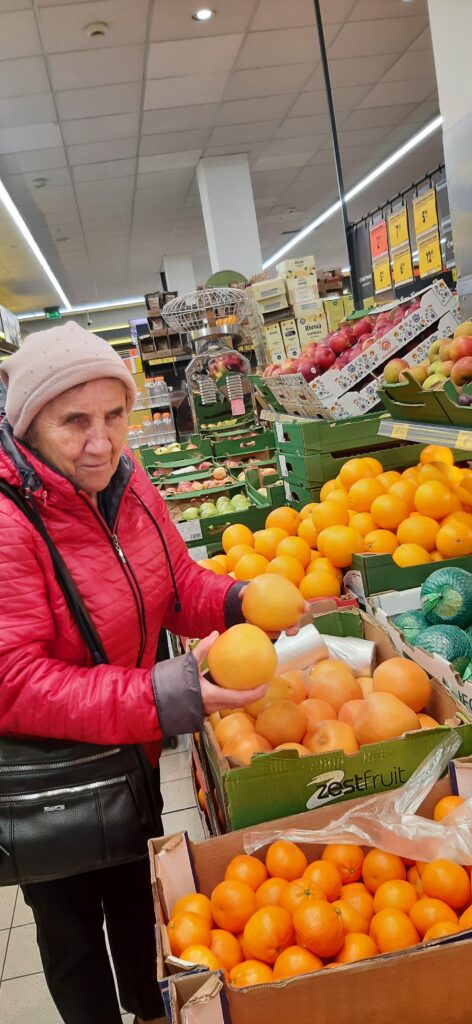 uczestnik wybiera pomarańcze na targu