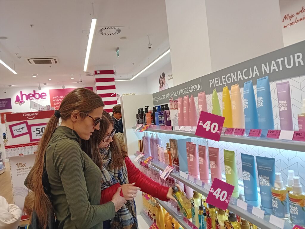 asystent z uczestnikiem podczas zakupów w drogerii