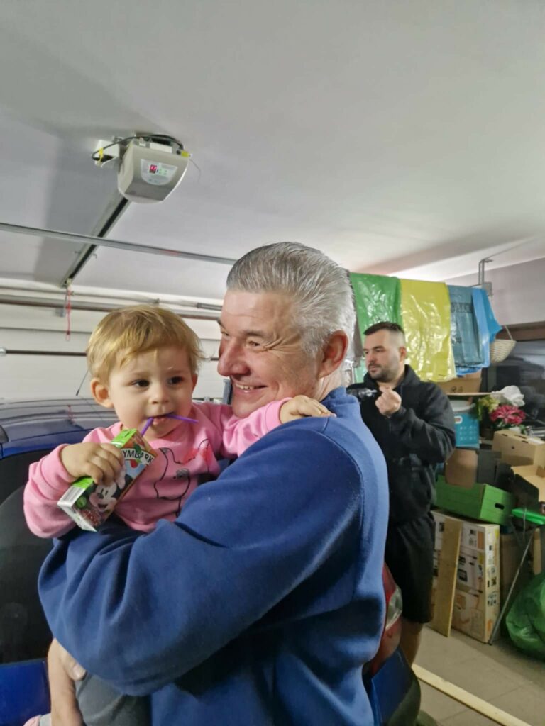 uczestnik z dzieckiem na rękach podczas spotkania w przedszkolu