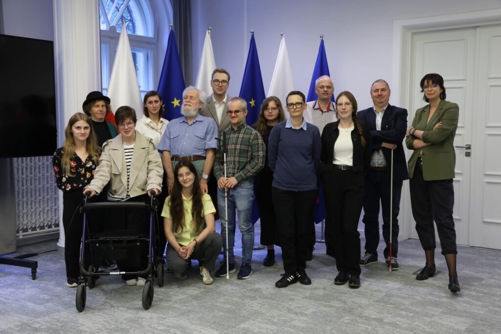 zdjęcie wspólne uczestników konferencji w tym uczestnika i asytenta