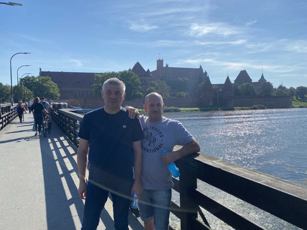 uczestnik z asystentem podczas wycieczki do Malborka - na pomoście