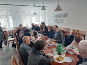 uczestnicy spotkania, siedzący przy długim stole