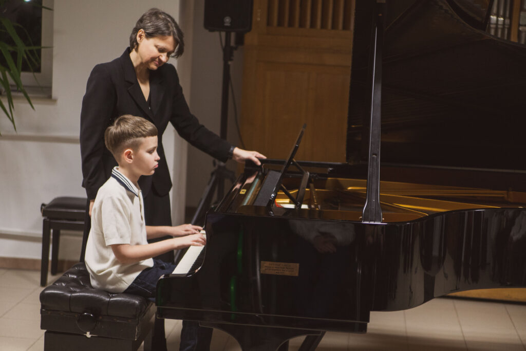 chłopiec grający na fortepianie 