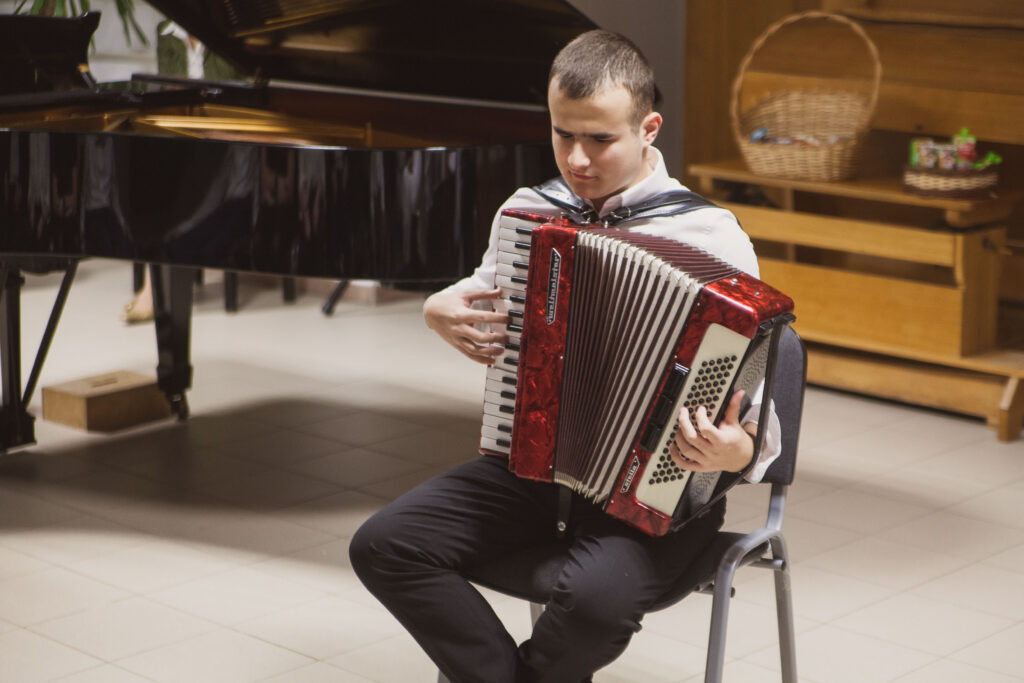 uczeń grający na harmonii